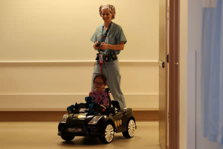 Doctor Daniela Carvalho controls Andrea Destraio, 5, remotely as Rady Children's Hospital unveil a program that uses remote control cars, donated by the local police officers charity, to take young patients to the operating room, in San Diego, California, U.S. September 19, 2017. REUTERS/Mike Blake