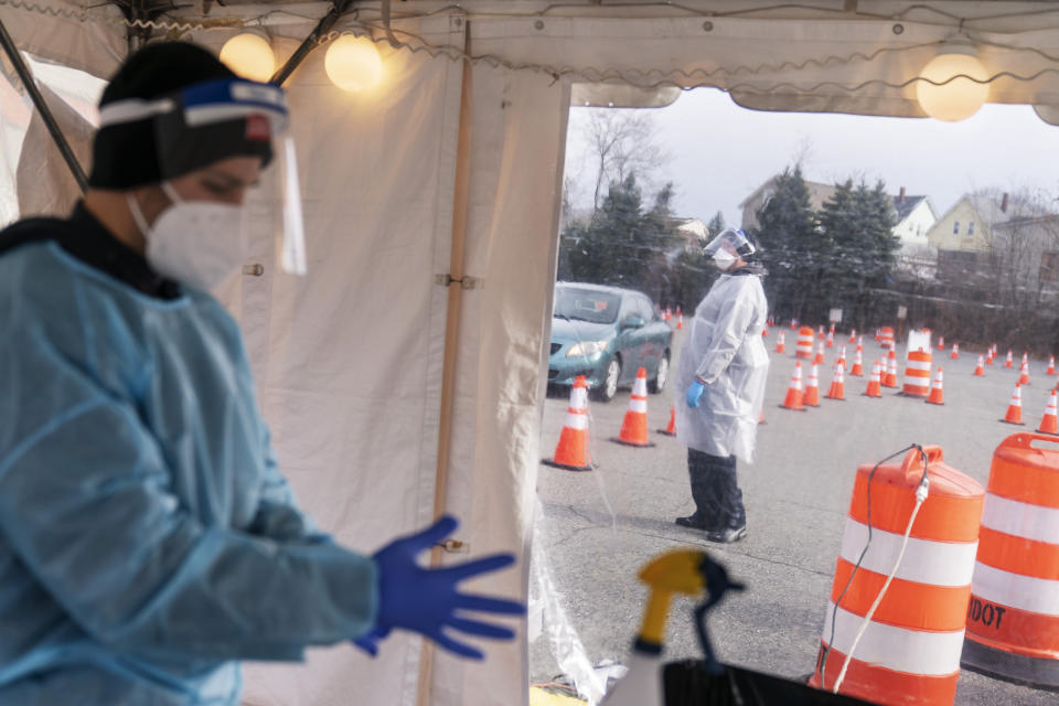 FILE - In this Dec. 9, 2020, file photo, health care workers prepare to test motorists for COVID-19 at a testing site outside McCoy Stadium in Pawtucket, R.I. As officials met to discuss approval of a COVID-19 vaccine on Thursday, Dec. 10, the number of coronavirus deaths has grown bleaker than ever. (AP Photo/David Goldman, File)