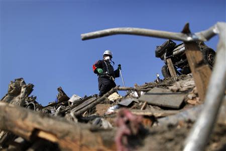A firefighter searches for the remains of victims in Rikuzentakata, Iwate Prefecture, after the area was devastated by a magnitude 9.0 earthquake and tsunami in this March 29, 2011 file photo. REUTERS/Damir Sagolj/Files