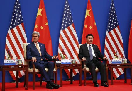 U.S. Secretary of State John Kerry and China's President Xi Jinping (R) sit next to each other as they participate in a Joint Opening Session of the U.S.-China Strategic and Economic Dialogue known as the "S&ED" at the Diaoyutai State Guesthouse in Beijing, July 9, 2014. REUTERS/Jim Bourg