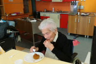In this photo taken on April 6, 2020, 103-year-old Ada Zanussi, eats her meal at the nursing home "Maria Grazia" in Lessona, northern Italy, after recovering from Covid-19 infection. To recover from coronavirus infection, as she did, Zanusso recommends courage and faith, the same qualities that have served her well in her nearly 104 years on Earth. The new coronavirus causes mild or moderate symptoms for most people, but for some, especially older adults and people with existing health problems, it can cause more severe illness or death. (Residenza Maria Grazia Lessona via AP Photo)