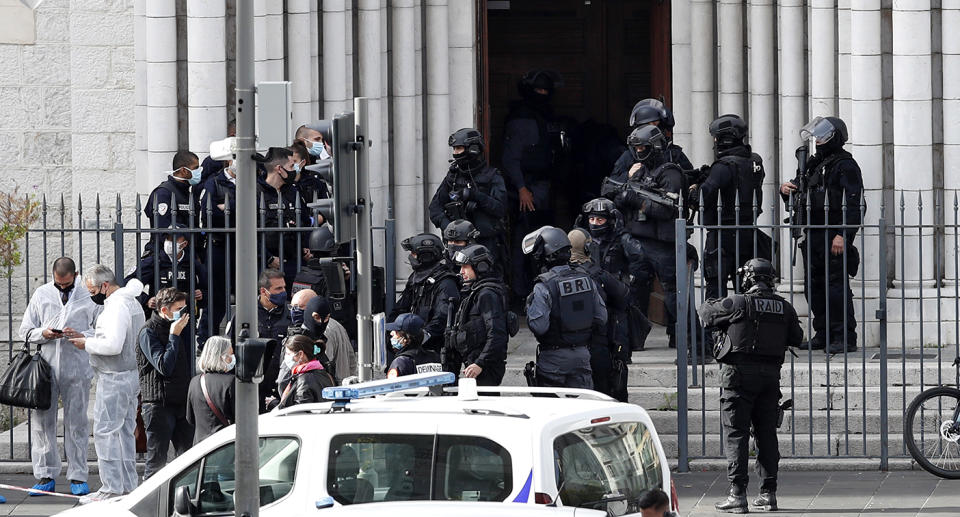 French police officers stand at the entrance of the Notre Dame Basilica church in Nice following a knife attack.