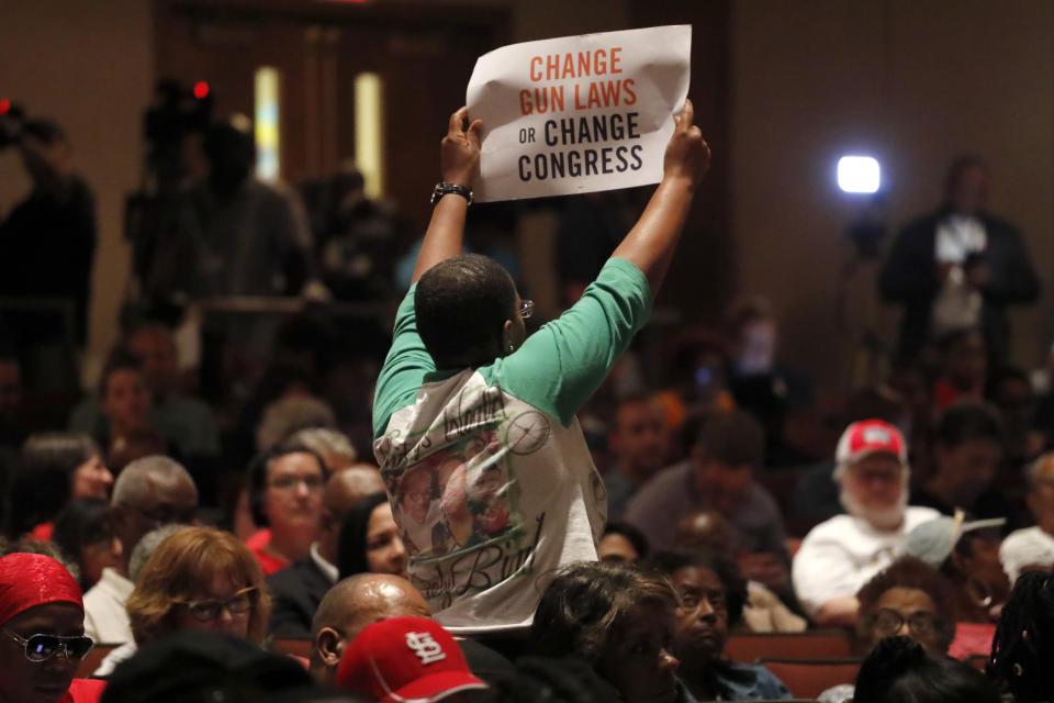 In this Wednesday, Aug. 28, 2019 photo, Erica Jones holds up a sign during a town hall to discuss the epidemic of gun violence and shocking number of children killed this summer in St. Louis. Jones, whose adult daughter was shot and killed in 2015, is like many parents desperately seeking a way to curb the gun violence that has killed at least a dozen children in the high-crime city already this year. (AP Photo/Jeff Roberson) | Jeff Roberson—AP