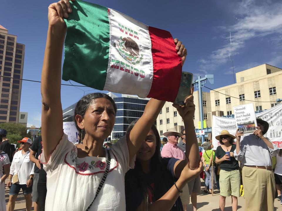 <p>Margarita Perez of Albuquerque, with her daughter by her side, holds up a Mexican flag during a protest on Civic Plaza in Albuquerque, N.M., on Saturday, June 30, 2018. Perez was among thousands who gathered on the plaza to voice their opposition to U.S. immigration policies and President Donald Trump. (Photo: Susan Montoya Bryan/AP) </p>