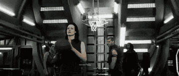 Sigourney Weaver as Ellen Ripley makes a backwards basketball shot in Alien: Resurrection