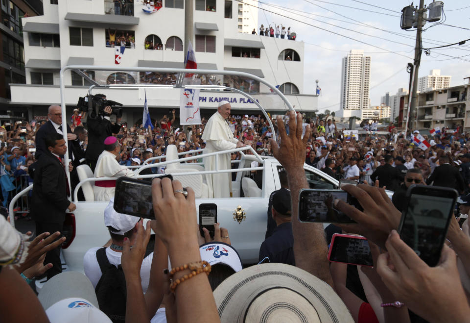 People take pictures with their mobile phones as Pope Francis rides the pope mobile through the streets of Panama City, Panama, Wednesday, Jan, 23, 2019. Pope Francis is in Panama to attend World Youth Day, the church's once-every-three-year pep rally that aims to invigorate the next generation of Catholics in their faith. (AP Photo/Rebecca Blackwell)