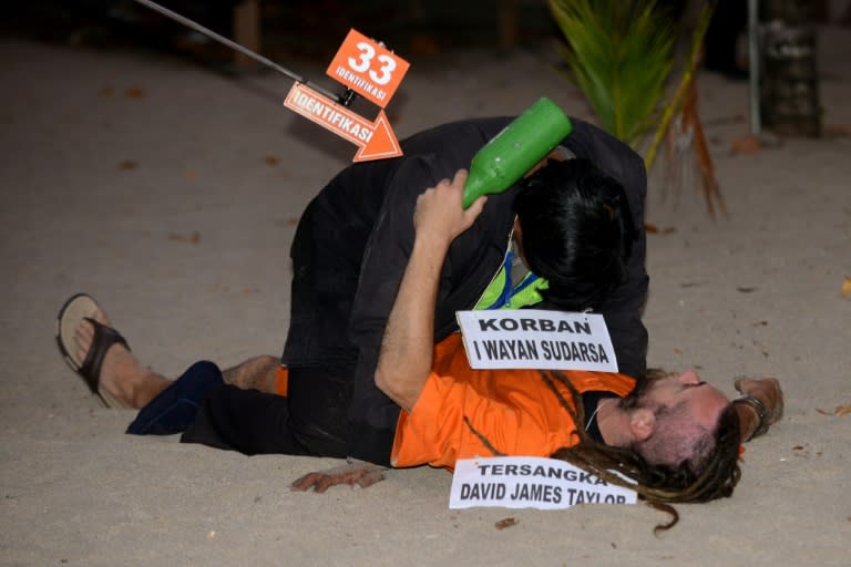 Detained British national David Taylor (bottom, in orange) re-enacts events at the crime scene were an Indonesian traffic policeman was killed at Legian beach in Kuta on Indonesia's resort island of Bali on August 31, 2016