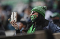 A Marshall fan films the opening kickoff of an NCAA college football game on Saturday, Dec. 5, 2020, in Huntington, W.Va. (Sholten Singer/The Herald-Dispatch via AP)