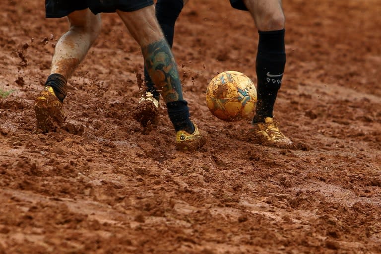 Unos aficionados juegan al fútbol en un campo de tierra en Sao Paulo el 17 de febrero de 2024 (Miguel Schincariol)