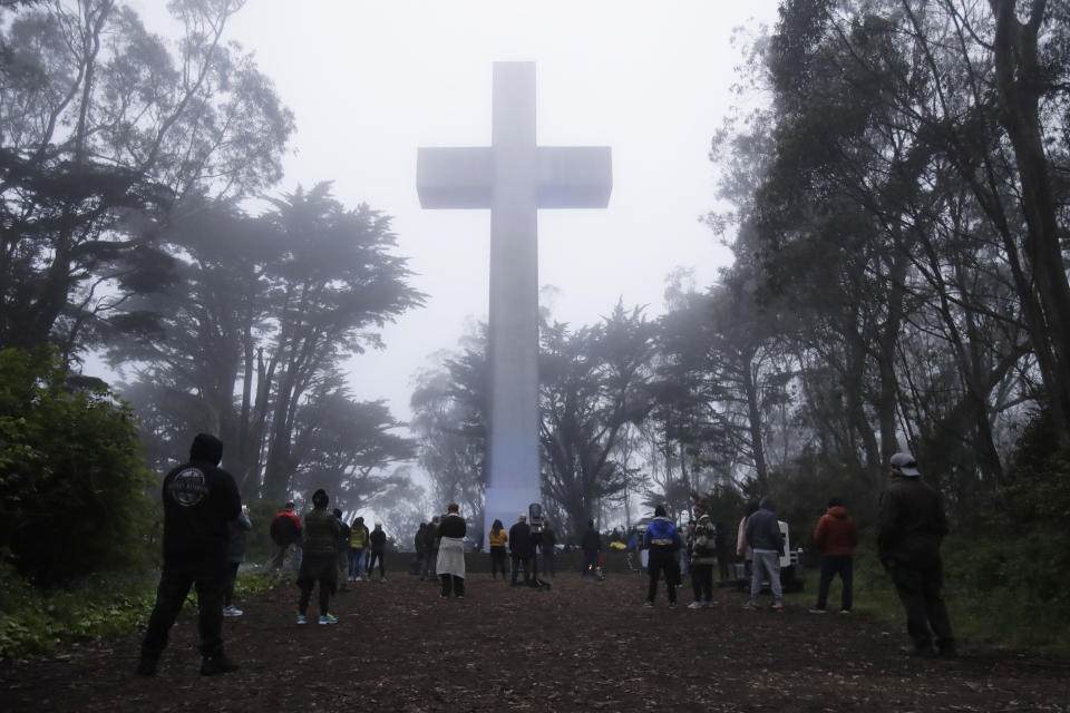 People gather at the Mount Davidson cross in San Francisco, Sunday, April 12, 2020. Mount Davidson's annual Easter Sunrise Service was canceled for San Francisco's shelter in place orders over coronavirus concers. (AP Photo/Jeff Chiu)