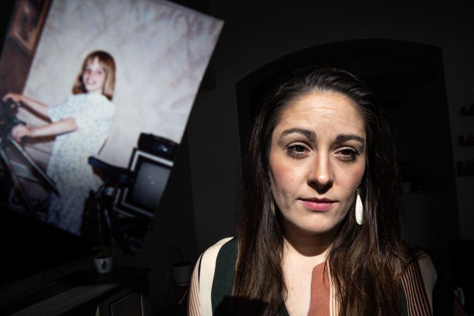 Kimber Biggs (right) poses for a portrait next to a photograph of her sister Mikelle Biggs (left) at her home in Gilbert on Jan. 25, 2024. Mikelle Biggs, who was 11 years old, disappeared while riding her bike near her home in Mesa on Jan. 2, 1999.