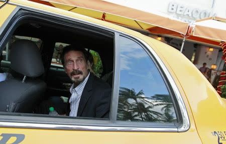 Computer software pioneer John McAfee speaks with a reporter from a taxi outside his hotel in Miami Beach, Florida December 13, 2012. REUTERS/Joe Skipper