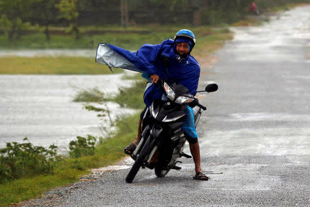 A man struggles against wind and rain as Doksuri storm hits the land in Ha Tinh province, Vietnam September 15, 2017. REUTERS/Kham