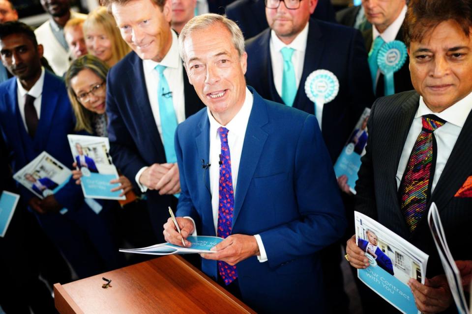 Nigel Farage signs a copy of his party’s manifesto following its launch in Merthyr Tydfil (PA Wire)