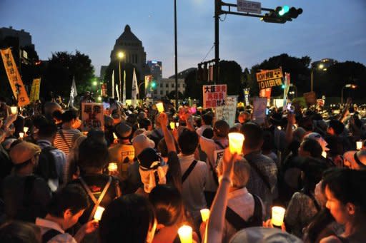 Protesters hold lit candles and placards as they take part in a rally in front of Japan's parliament, to demonstrate against the use of nuclear power following the 2011 Fukushima atomic crisis, in Tokyo