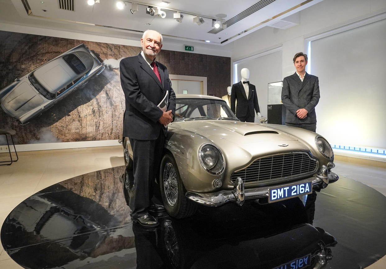 Producer Michael G. Wilson and Associate Producer Gregg Wilson seen with a silver birch Aston Martin DB5 stunt car at the 60 Years of James Bond auction, Christies. (PA)