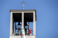 Parrish priest Maurizio Mirilli celebrates Palm Sunday mass from the his church's bell tower, in Rome, Sunday, April 5, 2020. Churches are closed to faithful all over Italy due to the coronavirus outbreak. The new coronavirus causes mild or moderate symptoms for most people, but for some, especially older adults and people with existing health problems, it can cause more severe illness or death. (Roberto Monaldo/LaPresse via AP)