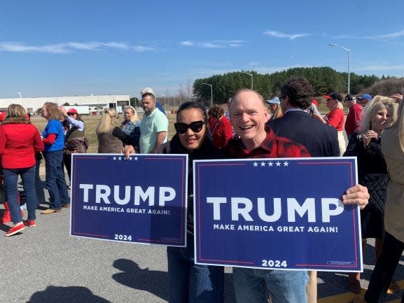 Jennette, 47, and John, 63, Vassar, of Simpsonville held up a Trump sign while in line for the airport welcome of former President Donald Trump.