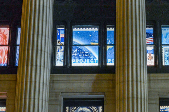 Enlarged reproductions of the "20th Anniversary Moon Landing" and "Project Mercury" stamps adorn the windows of the William H. Gross Stamp Gallery at the National Postal Museum.