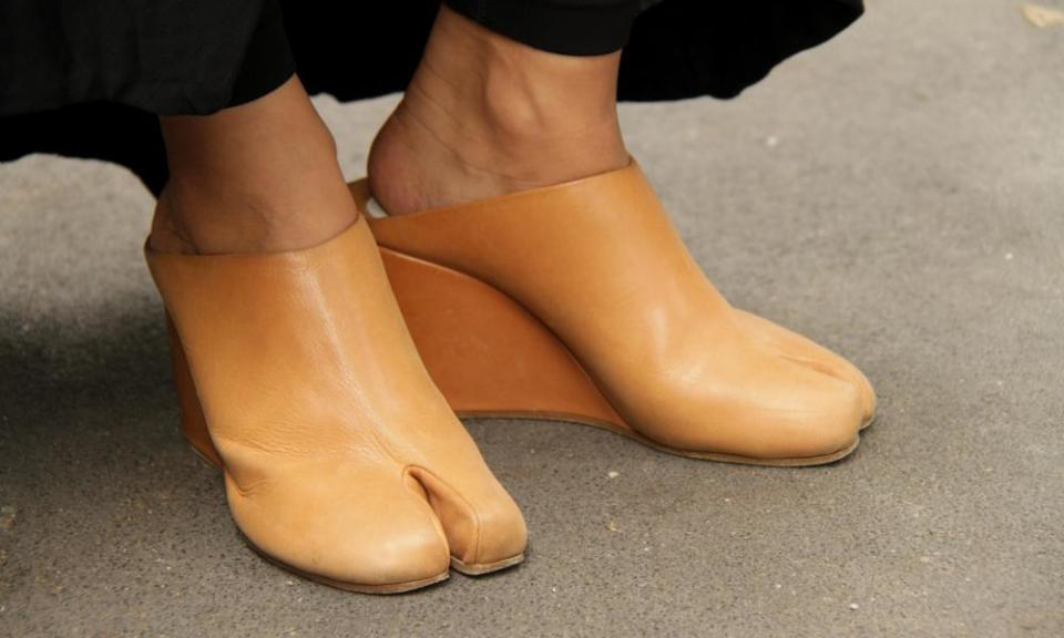 An attendee of a Giorgio Armani runway show in Milan in 2015 sports Margiela tabi shoes.