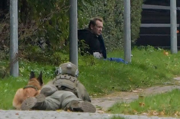 A police marksman and his dog observe the reported escapee  