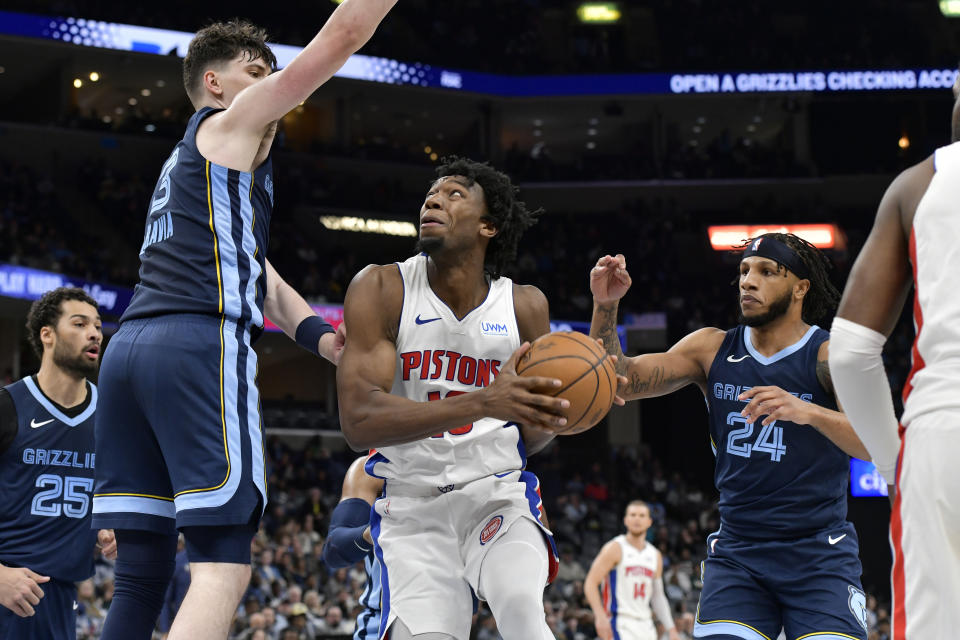 Detroit Pistons forward Tosan Evbuomwan, center, looks to shoot between Memphis Grizzlies forwards Jake LaRavia (3) and Lamar Stevens (24) in the second half of an NBA basketball game Friday, April 5, 2024, in Memphis, Tenn. (AP Photo/Brandon Dill)