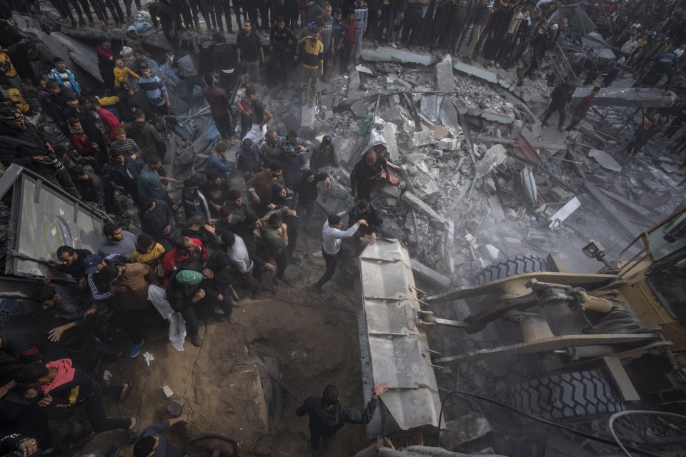 Palestinians search for bodies and survivors in the rubble of a residential building destroyed in an Israeli airstrike, in Rafah southern Gaza Strip, Wednesday, Dec. 20, 2023. (AP Photo/Fatima Shbair)