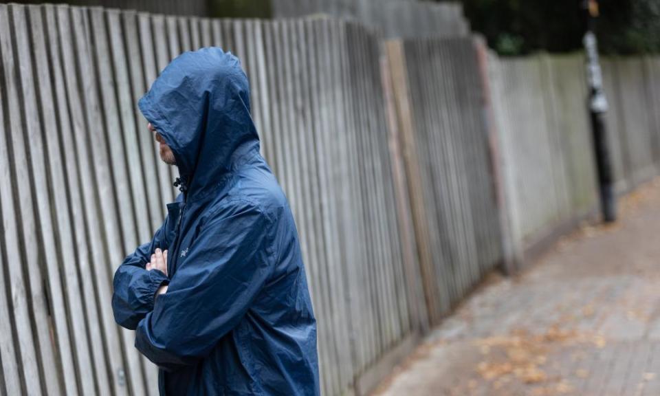 A scam victim who wants to remain anonymous wearing a rain jacket with hood pulled up. 