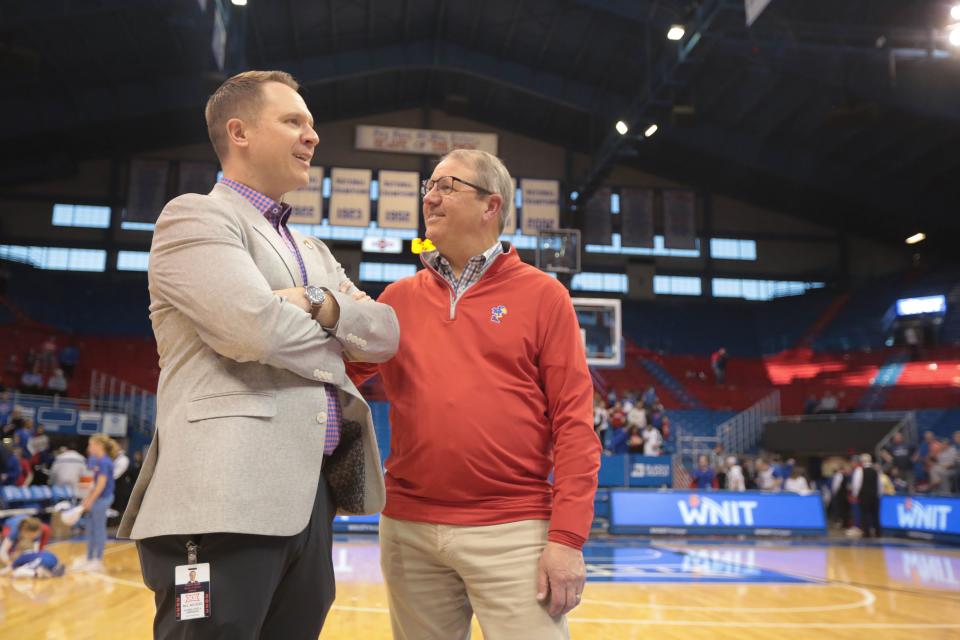 As the Kansas women's basketball team celebrates its 2023 Postseason WNIT title earlier this year, Travis Goff (left) and Douglas Girod (right) follow along on the court. Goff is the university's athletic director, and Girod its chancellor.