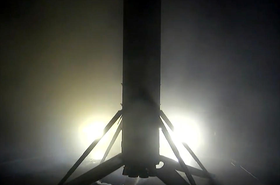 A SpaceX Falcon 9 first stage stands vertical after landing on the drone ship 
