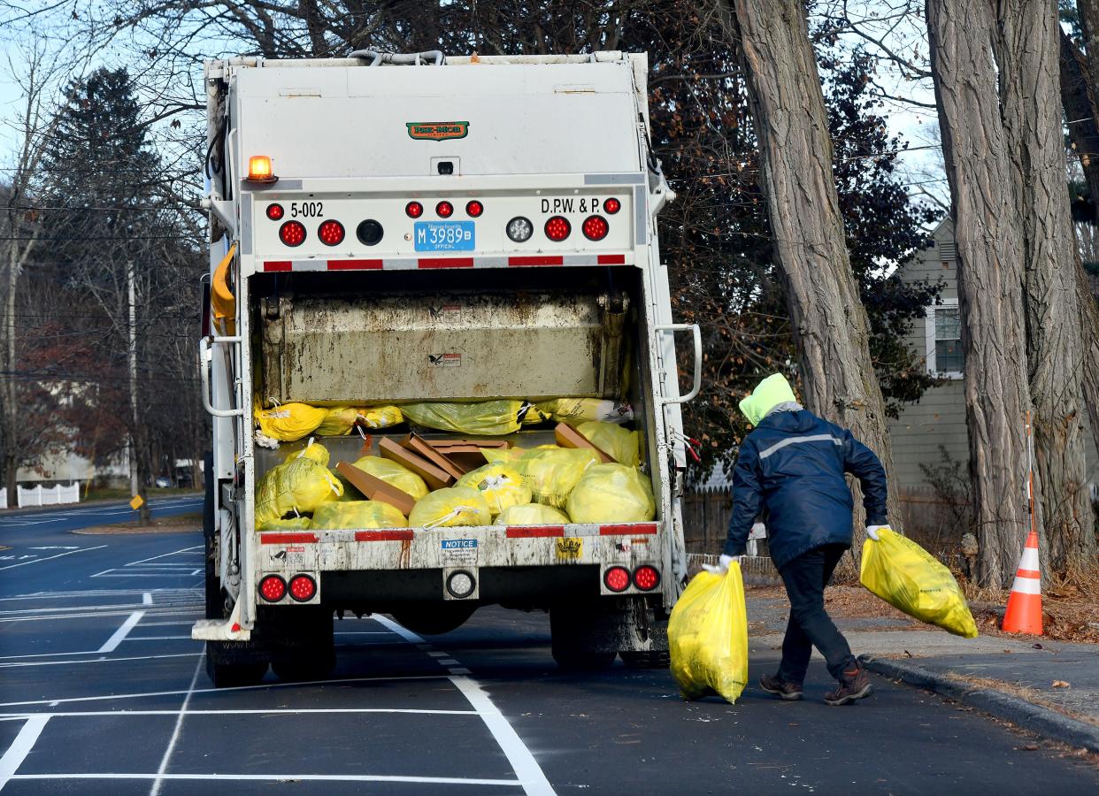 WORCESTER - A crew collects trash bags along Mill Street on Thursday.