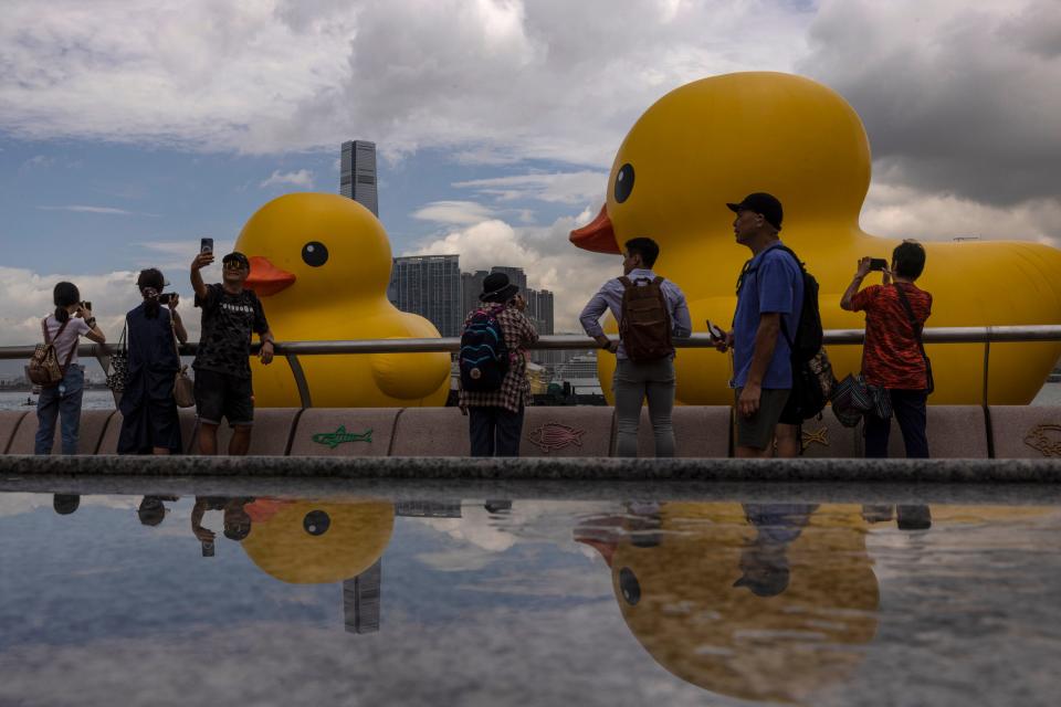 June 9, 2023: Members of the public photograph an art installation called "Double Ducks" by Dutch artist Florentijn Hofman at Victoria Harbour in Hong Kong. Two giant inflatable ducks made a splash in Hong Kong's Victoria Harbor on Friday, marking the return of a pop-art project that sparked a frenzy in the city a decade ago.