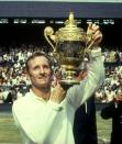 <p>Rod Laver of Australia holds the trophy aloft after his victory in the Men's Singles event in 1970.</p>