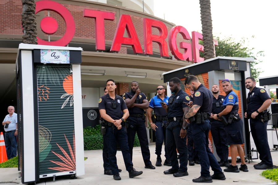 FILE – Police officers stand outside of a Target store as a group of people across the street protest against Pride displays in the store on June 1, 2023, in Miami. Target confirmed that it won’t be carrying its LGBTQ+ merchandise for Pride month in June, 2024, in some stores after the discount retailer received backlash last year for its assortment. (AP Photo/Lynne Sladky, File)