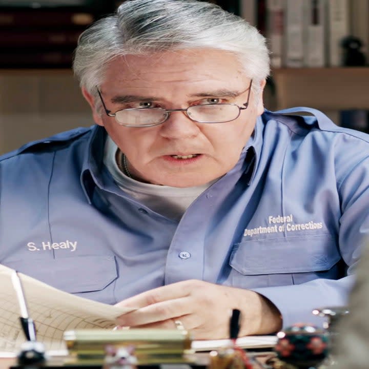 Close-up of Michael as Sam behind a desk