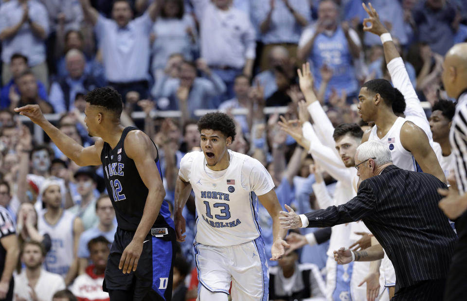 North Carolina coach Roy Williams reaches for Cameron Johnson (13) following Johnson's basket against Duke while Duke's Javin DeLaurier (12) looks back during the second half of an NCAA college basketball game in Chapel Hill, N.C., Saturday, March 9, 2019. North Carolina won 79-70. (AP Photo/Gerry Broome)