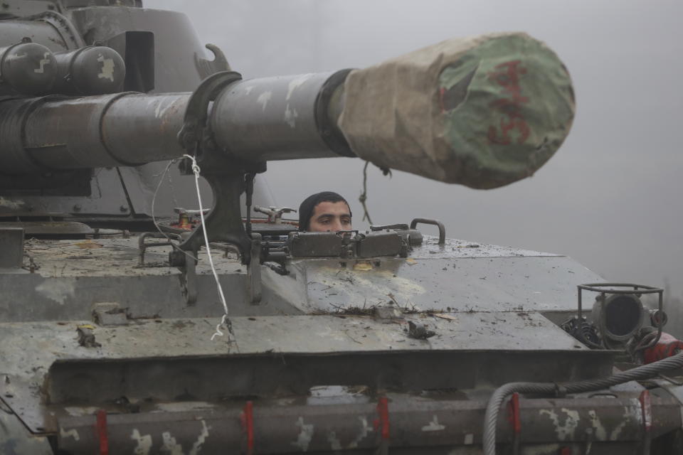 An Armenian soldier drives a self-propelled artillery unit during the withdrawal of Armenian troops from the separatist region of Nagorno-Karabakh, Wednesday, Nov. 18, 2020. A Russia-brokered cease-fire to halt six weeks of fighting over Nagorno-Karabakh stipulated that Armenia turn over control of some areas it holds outside the separatist territory's borders to Azerbaijan. Armenians are forced to leave their homes before the region is handed over to control by Azerbaijani forces. (AP Photo/Sergei Grits)