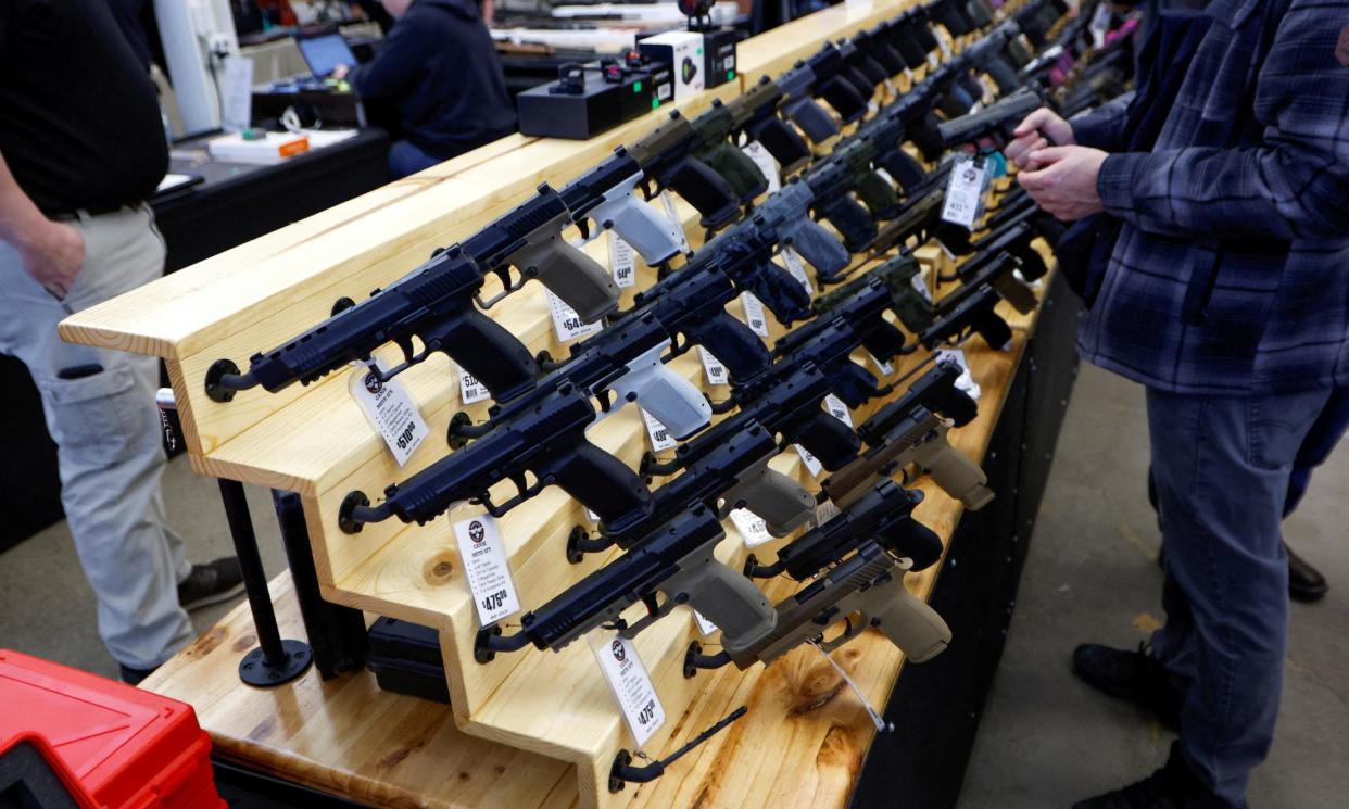 <span>Customers browse at the Des Moines Fairgrounds Gun Show in Des Moines. The US justice department said the sale of firearms on the internet and at gun shows would be subject to mandatory background checks.</span><span>Photograph: Jonathan Ernst/Reuters</span>