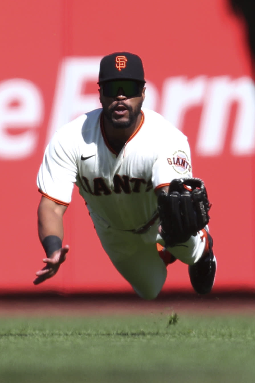 San Francisco Giants' Jaylin Davis catches a ball hit by St. Louis Cardinals' Harrison Bader during the fifth inning of a baseball game in San Francisco, Monday, July 5, 2021. (AP Photo/Jed Jacobsohn)