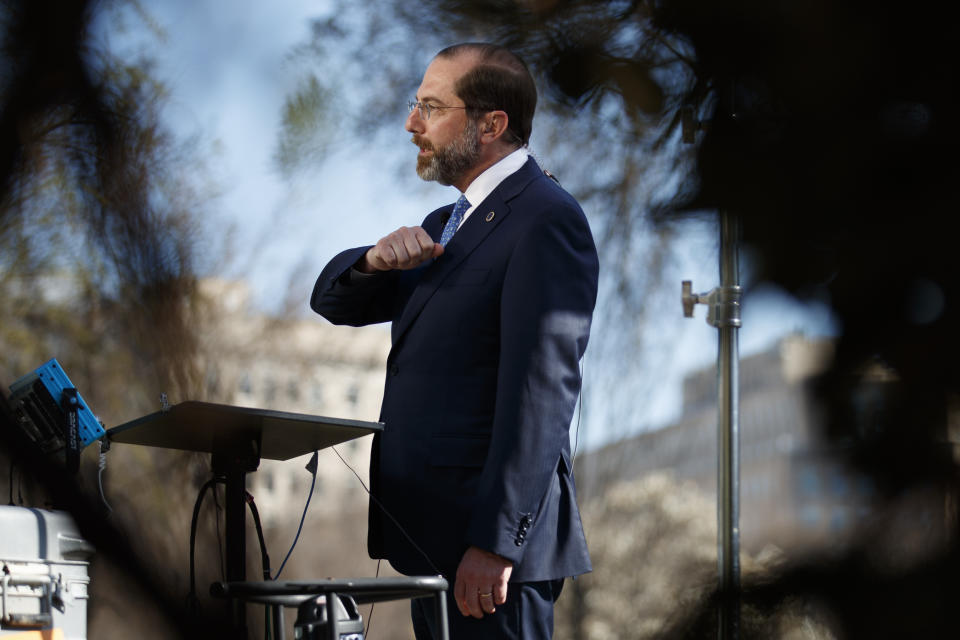 Health and Human Services Secretary Alex Azar demonstrates how to greet others with an elbow as he speaks during a television interview outside the West Wing of the White House in Washington, Monday, March, 9, 2020. (AP Photo/Carolyn Kaster)