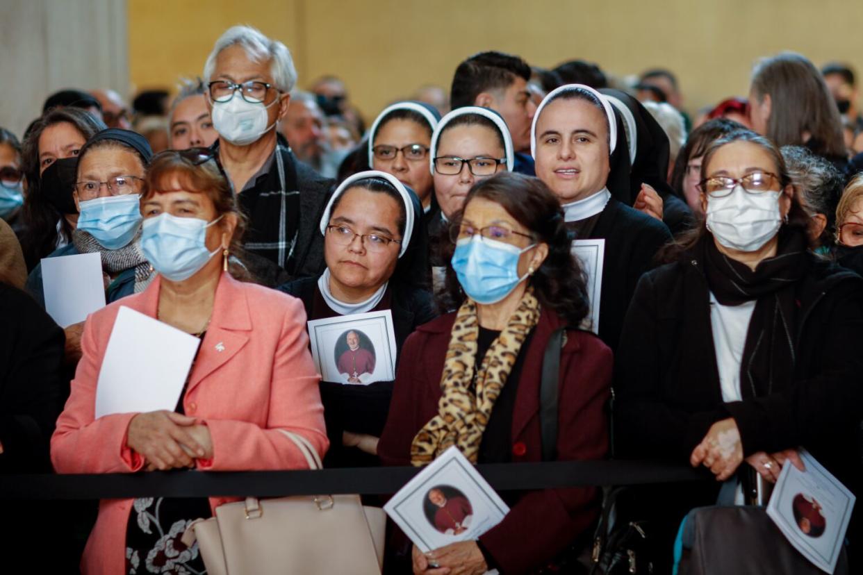 Visitors watch as Archbishop Jose H. Gomez leads the funeral procession ahead of the casket of Bishop.