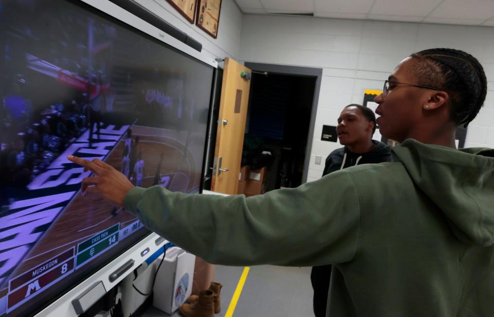 Travon Cooper, left, and Isaac Sanders break down action, while viewing a replay of Cass Tech's March 25 state championship victory in boys basketball. They were gathered by the Detroit Free Press at Cass Tech on Wednesday, May 3, 2023, to talk about their goals for the future, from becoming professional sports executives, running a NBA team one day, or becoming a sports journalist, in the case of Sanders.