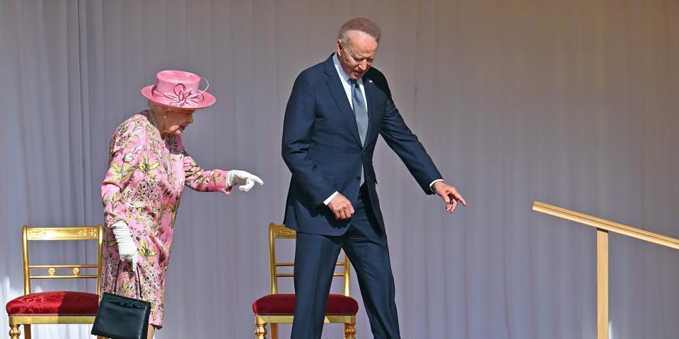 Queen Elizabeth and Joe Biden stand together on a stage.