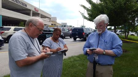 Journalist E.B Furgurson (R) takes notes with two other people as police officers respond to an active shooter inside a city building in Annapolis, Maryland, U.S., June 28, 2018. REUTERS/Greg Savoy