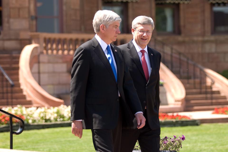 Prime Minister Stephen Harper right, and Michigan Governor Rick Snyder walk in front of the original Hiram Walker and Sons estate on the banks of the Detroit River in Windsor, Ontario, Canada, on Friday, June 15, 2012, ahead of an announcement for a new $1-billion bridge connecting the city with Detroit. (AP Photo/The Canadian Press,Mark Spowart )