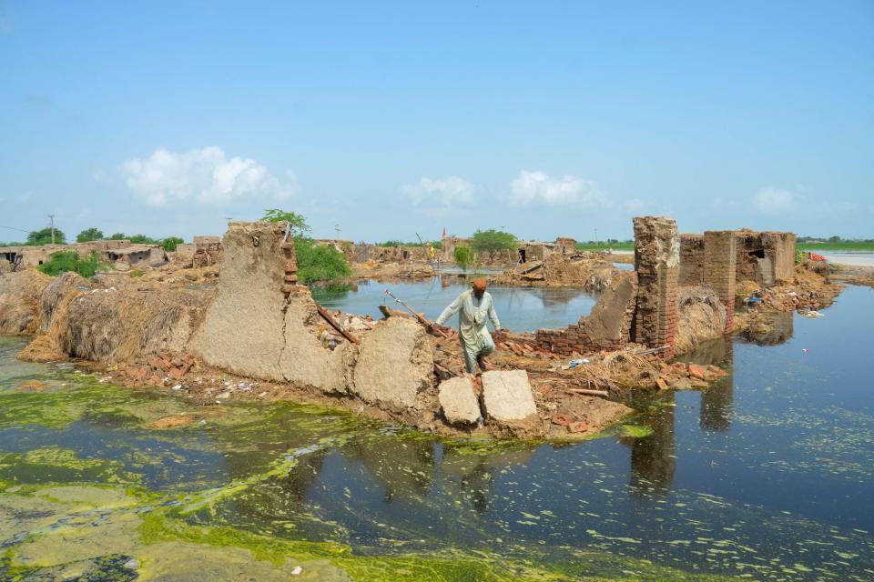 A flood affected man walks over his collapsed mud house after heavy monsoon rains in Jaffarabad district, Balochistan (Getty Images)