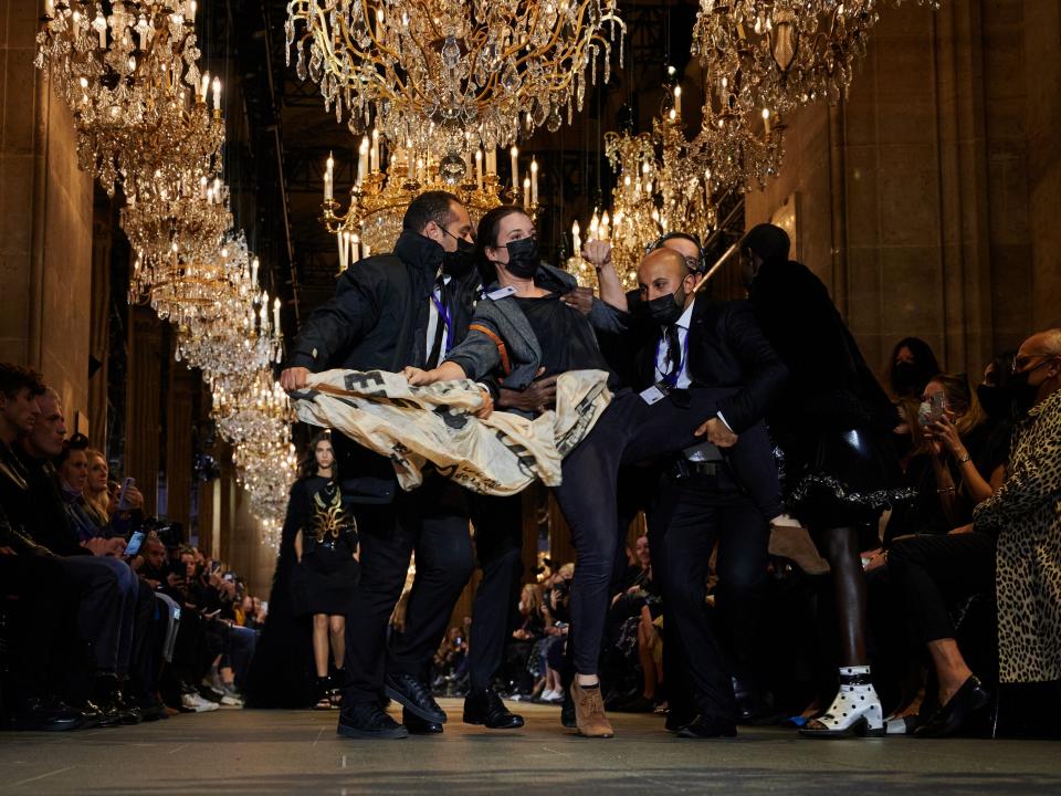 Protester walks down the runway at Louis Vuitton's Paris Fashion Week show.