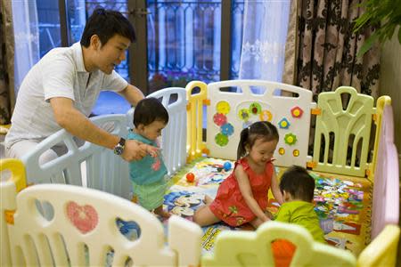 Tony Jiang poses with his three children at his house in Shanghai September 16, 2013. In December 2010, REUTERS/Aly Song