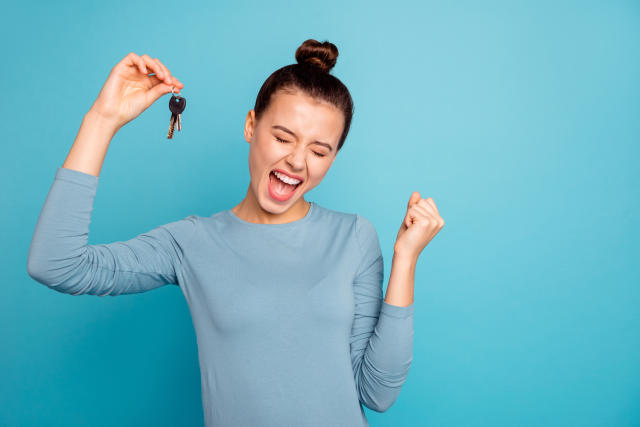 Portrait of delighted lady luck lucky triumph raise fists close eyes content rejoice scream shout yeah mover move in settlement loan beautiful bun trendy stylish sweater isolated on blue background.