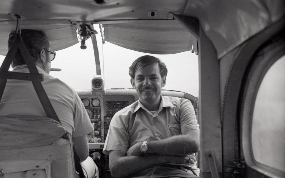 This image is titled, “Riding Shotgun,” where Galen Beery (center) is looking at the camera within an aircraft flying over Laos when he was USAID worker in 1970.